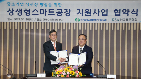 정재훈 한국수력원자력 사장(왼쪽)과 이상진 한국표준협회 회장이 30일 경주 한수원 본사에서 '상생형스마트공장' 지원사업 업무협약을 체결한 뒤 악수하고 있다. <한수원 제공>